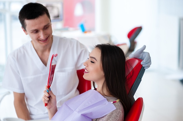 La jeune fille apprécie l'excellent travail du dentiste.