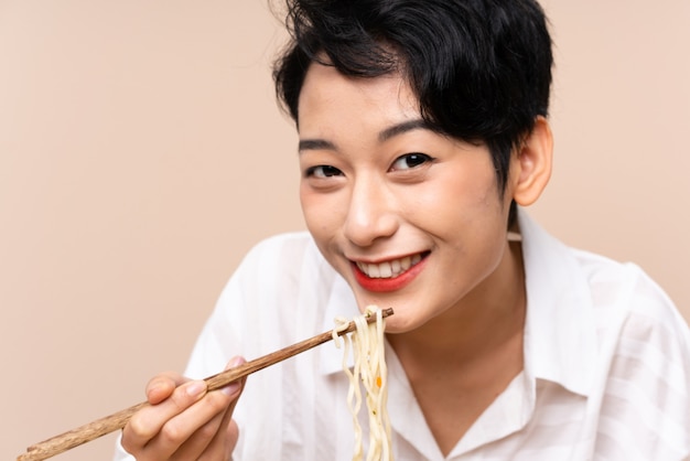 Jeune fille asiatique dans une table avec bol de nouilles