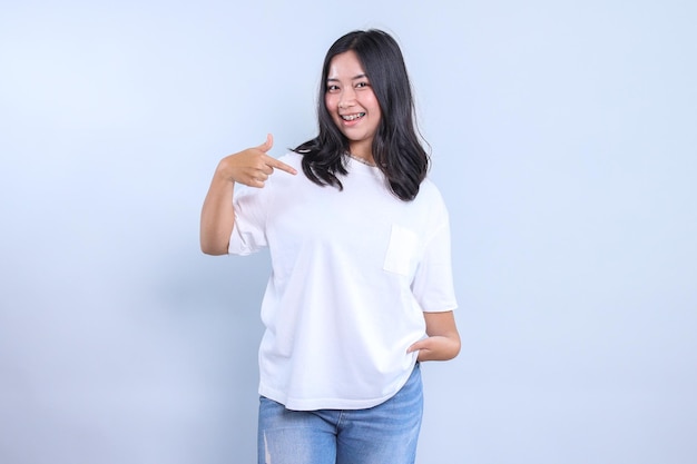 Une jeune fille asiatique portant un t-shirt blanc blanc pour la maquette montrant le dessin