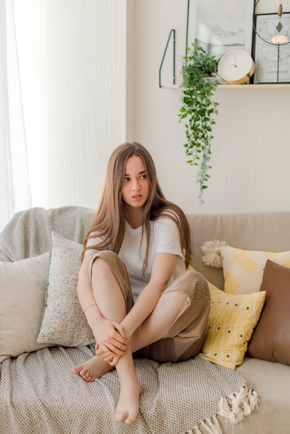 Jeune fille assise sur un canapé