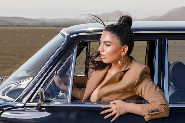 Jeune fille assise dans la voiture et regardant par la fenêtre Photo de haute qualité