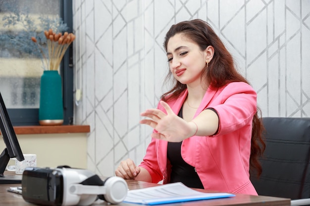 Jeune fille assise derrière un bureau et se sentant mal à l'aise Photo de haute qualité