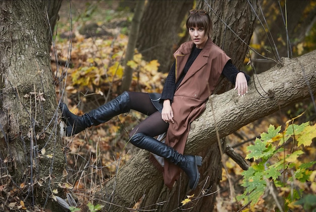 Jeune fille assise en plein air dans un paysage d'automne Fashion