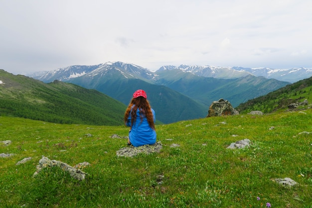 Jeune fille assise et regardant les montagnes