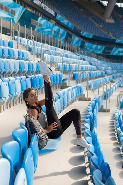 Jeune fille assise sur le siège du stade.