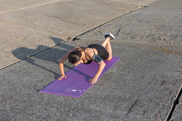 Une jeune fille athlétique mince en tenue de sport avec des imprimés en peau de serpent effectue une série d'exercices Fitness et mode de vie sain