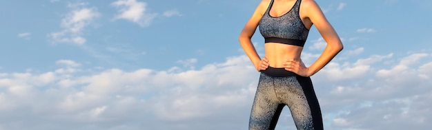 Une jeune fille athlétique mince en tenue de sport avec des imprimés en peau de serpent effectue une série d'exercices Fitness et mode de vie sain