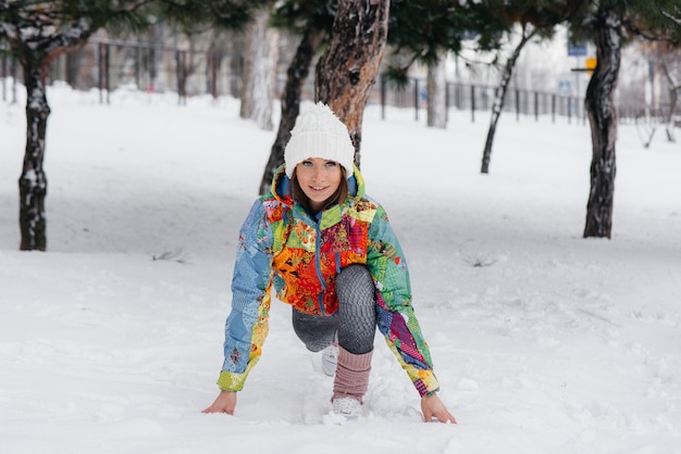 Une jeune fille athlétique se réchauffe avant de courir un jour de gel. Fitness, course à pied.