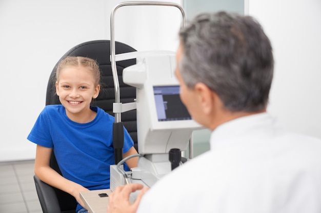 Jeune fille au bureau d'optique examinant la vue.