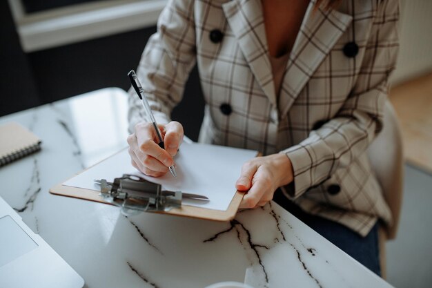 Jeune fille au bureau prenant des notes sur papier