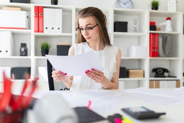 Une jeune fille au bureau tient un drap