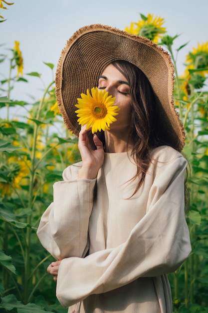 Jeune fille au chapeau sur un champ de tournesols