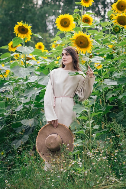 Jeune fille au chapeau sur un champ de tournesols