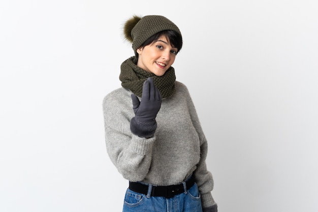 Jeune fille au chapeau d'hiver invitant à venir avec la main. Heureux que tu sois venu