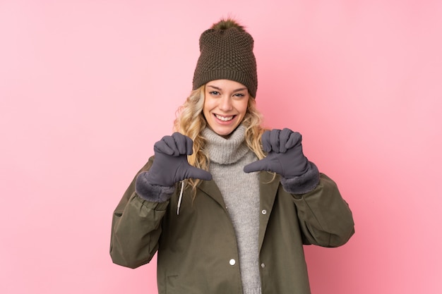 Jeune fille au chapeau d'hiver rose fier et satisfait de lui-même