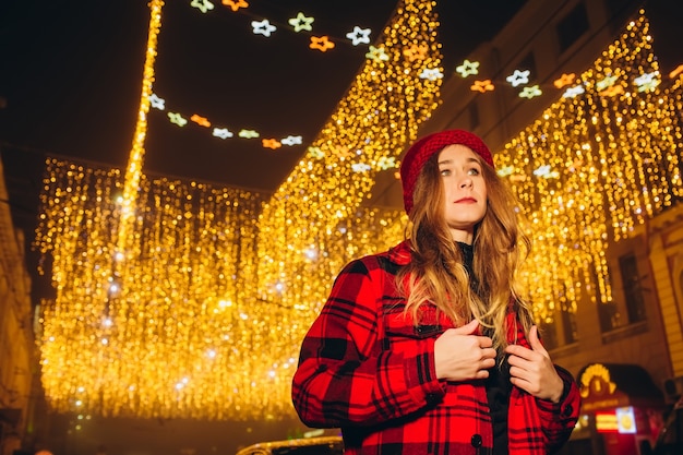 Jeune fille au chapeau rouge dans la rue le soir