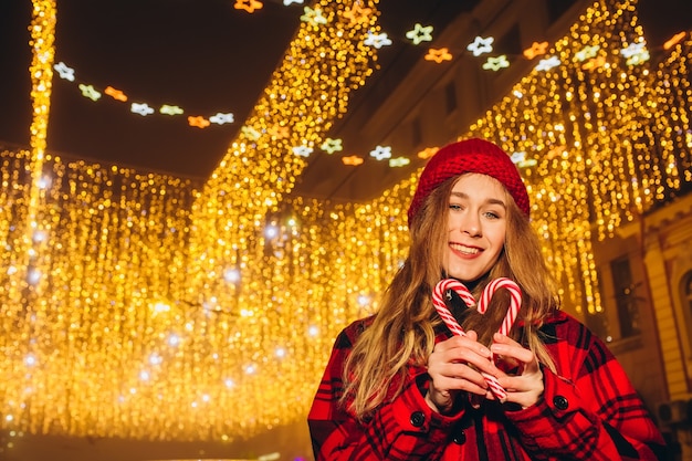 Jeune fille au chapeau rouge dans la rue le soir