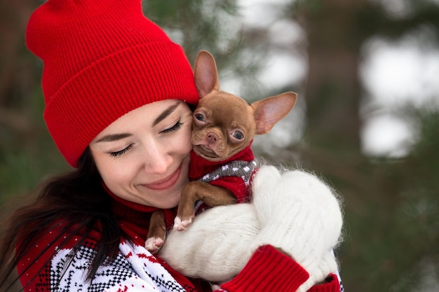 une jeune fille au chapeau rouge marche un jour d'hiver avec un chien, des chutes de neige