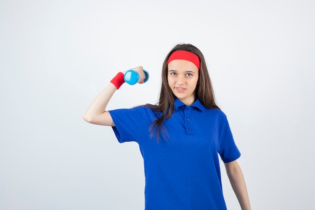 jeune fille aux cheveux longs dans la formation de bandeau avec des haltères de poids.