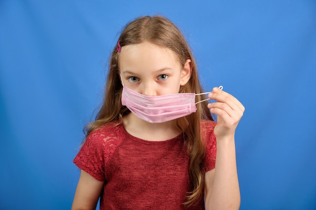 Jeune fille aux cheveux longs dans un masque médical de protection