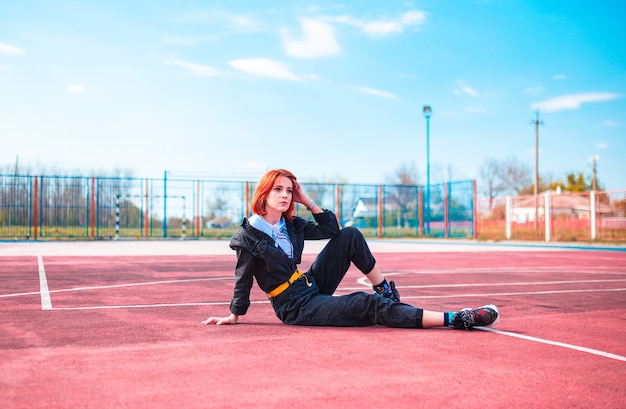 Une jeune fille aux cheveux rouges joue au basket