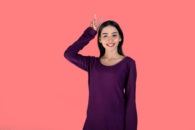 Jeune fille avant pose avec sourire sur fond rose modèle pakistanais indien