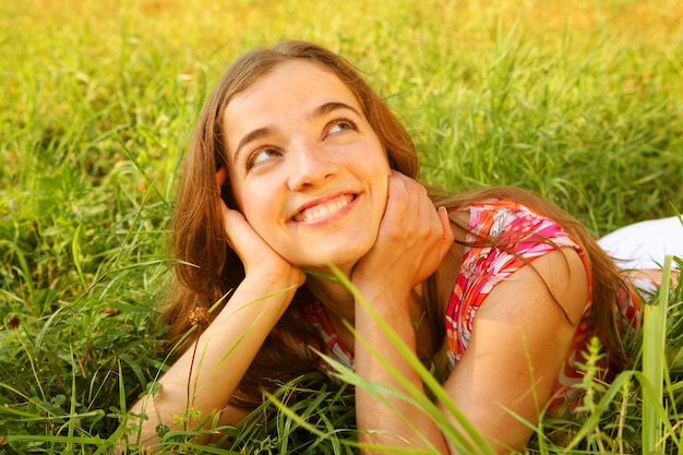 Jeune fille belle pose sur l'herbe