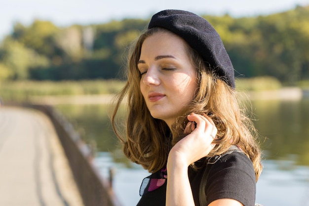 La jeune fille en béret et jupe dans le parc