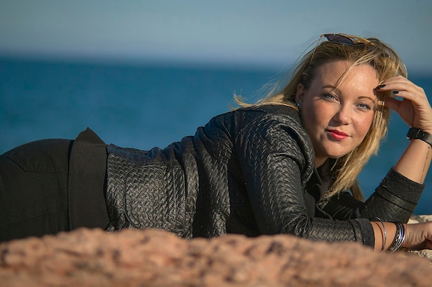 Jeune fille blonde allongée sur la falaise à l'heure du repos