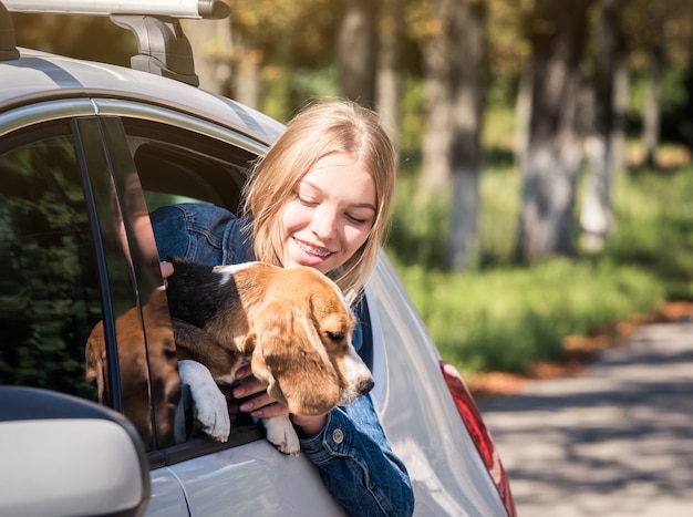 jeune fille blonde assise avec chiot dans la voiture