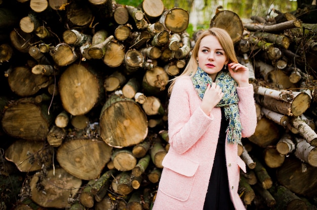 Jeune fille blonde au manteau rose posé