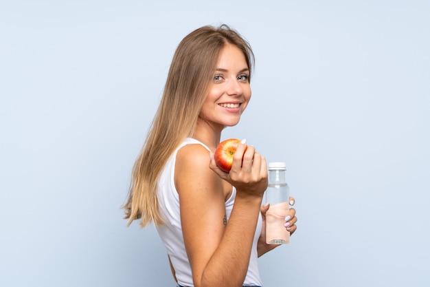 Jeune fille blonde avec une bouteille d'eau