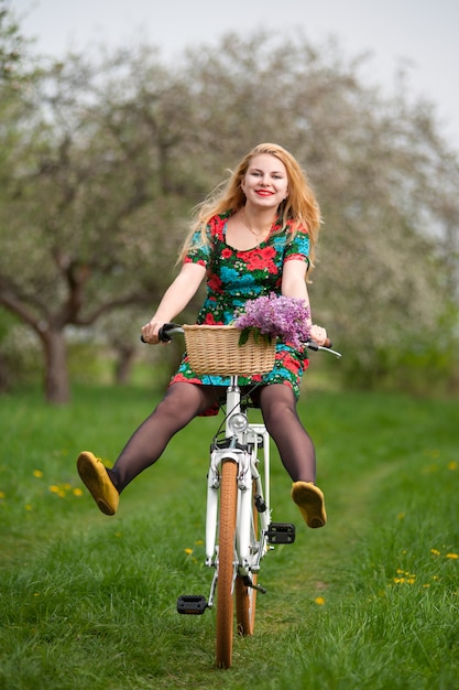 Jeune fille blonde chevauchant un vélo vintage