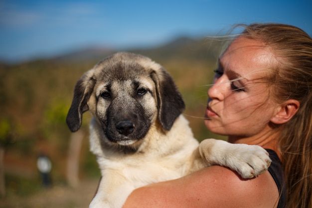 Jeune fille blonde jouant avec un chiot dogue espagnol