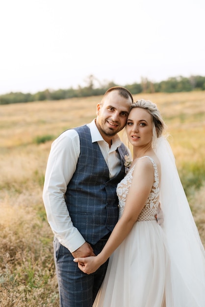 Jeune fille blonde mariée et le marié dans un champ