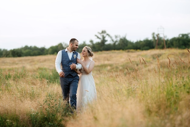 Jeune fille blonde mariée et le marié dans un champ