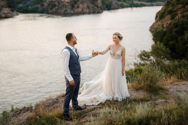 Jeune fille blonde mariée et marié près de la rivière