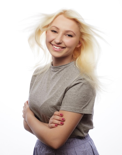 Une jeune fille blonde mignonne souriante sur un fond blanc