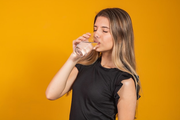 Jeune fille blonde s'hydrater de l'eau potable