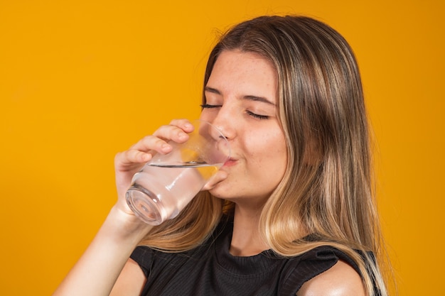 Jeune fille blonde s'hydrater de l'eau potable