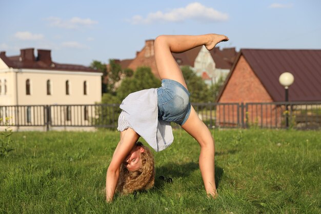 Une jeune fille blonde se tient dans les feuilles de raisins sauvages. photo de haute qualité