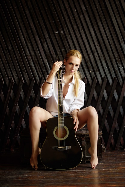 jeune fille blonde sexy jouant de la guitare