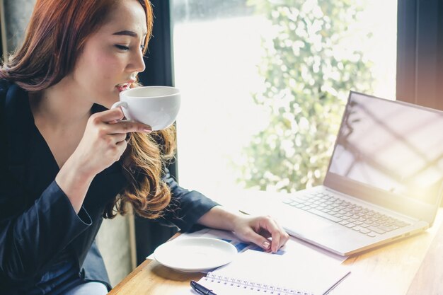 Jeune fille boit du café au café