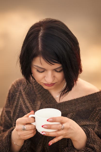 Jeune fille boit du café à l'extérieur des émotions