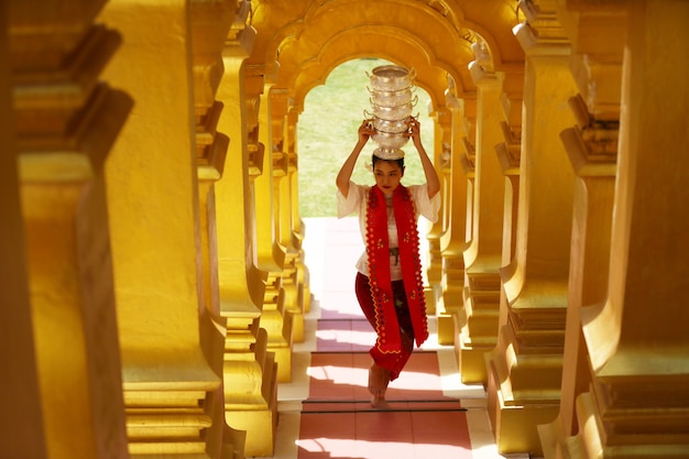 Jeune fille avec un bol de riz traditionnel birman sur la main à la belle pagode d'or au Myanmar