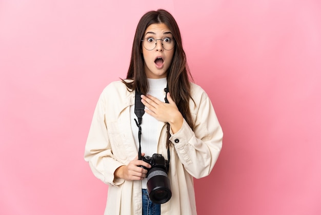 Jeune fille brésilienne photographe isolée sur rose surpris et choqué tout en regardant à droite