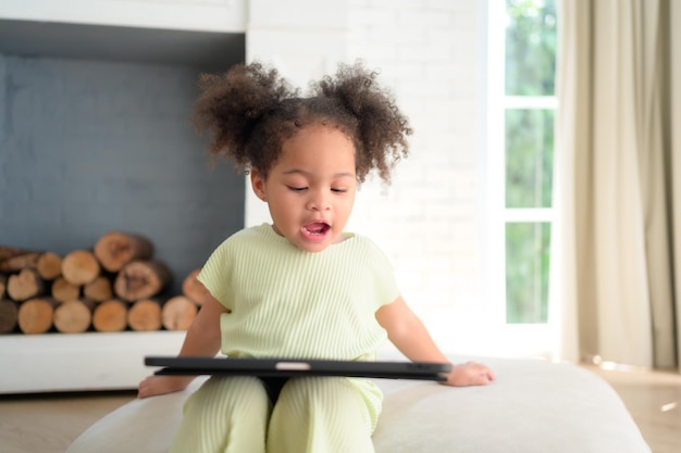 Une jeune fille brillante et mignonne avec sa tablette fidèle qui la rend heureuse et joyeuse