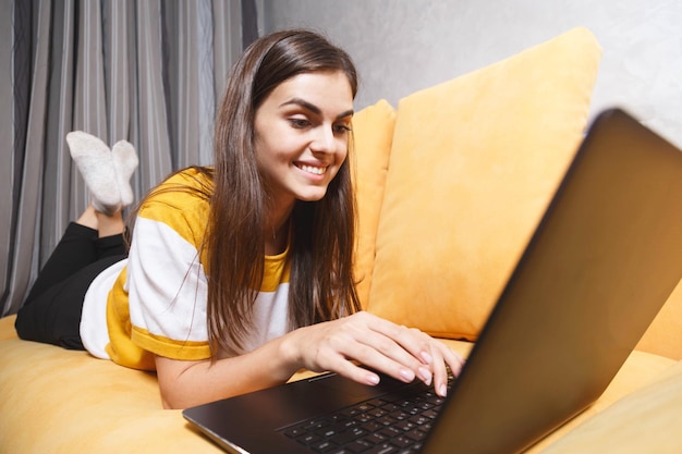 Jeune fille brune aux cheveux longs souriante portant