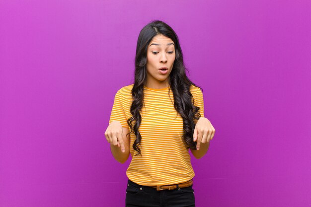 jeune fille brune avec la bouche ouverte pointant vers le bas