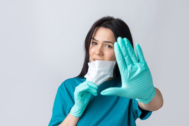 Une jeune fille brune dans un masque médical protecteur tient un coeur rose symbolise la vie Coronavirus